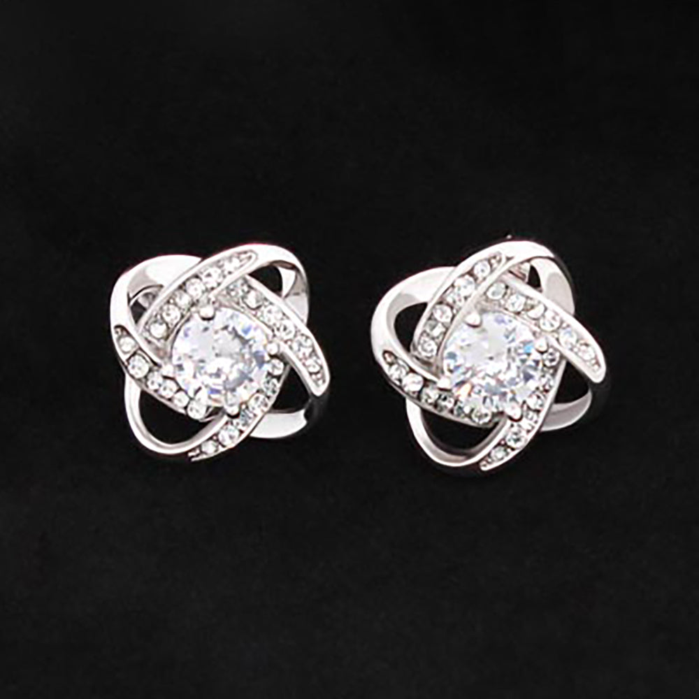 Love Knot Stud Earrings - Give your loved one some EXTRA sparkle! Love Knot Stud Earring Specs: Material: 14K White Gold over Stainless Steel 0.6” x 0.6” x 0.24” (15.7 mm x 15.7mm x 6mm) 6mm Diameter Center CZ Post Earrings With Push Backing