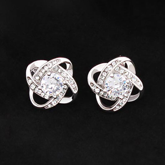 Love Knot Stud Earrings - Give your loved one some EXTRA sparkle! Love Knot Stud Earring Specs: Material: 14K White Gold over Stainless Steel 0.6” x 0.6” x 0.24” (15.7 mm x 15.7mm x 6mm) 6mm Diameter Center CZ Post Earrings With Push Backing