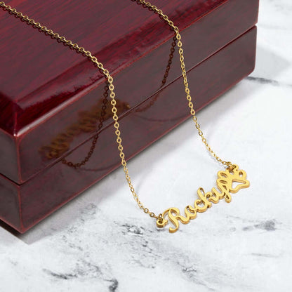 Gold "Rocky" paw print name necklace on wooden box from More Than Charms Name Necklace collection.